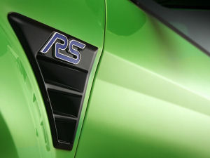 
Vue agrandie des sorties d'air latrales en aval des roues de la Ford Focus RS. Ces sorties sont recouvertes d'une laque noire, et exhibent le logo RS.

 