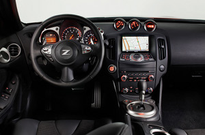
Vue de la planche de bord et du poste de conduite de la Nissan 370Z. L'ambiance est sombre est sportive. Les trois compteurs en haut de la console centrale crent une ambiance de voiture sportive,
 